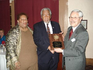 Dan Washington, chapter president (c), receives a 25 Year AFCEA Leadership Recognition Award from Bob Landgraf, regional vice president for the Northern California region. Joining them is Washington's wife, Lois, who was also thanked for her assistance.